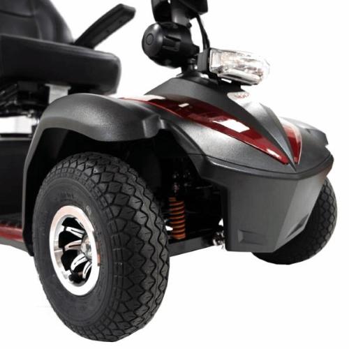 Scooter (Rosso) di medie dimensioni, sedile con numerose regolazioni: schienale, poggiatesta, larghezza e altezza braccioli, seduta - piantone dello sterzo regolabile - ruote a fianco alto per tutti i fondi stradali.